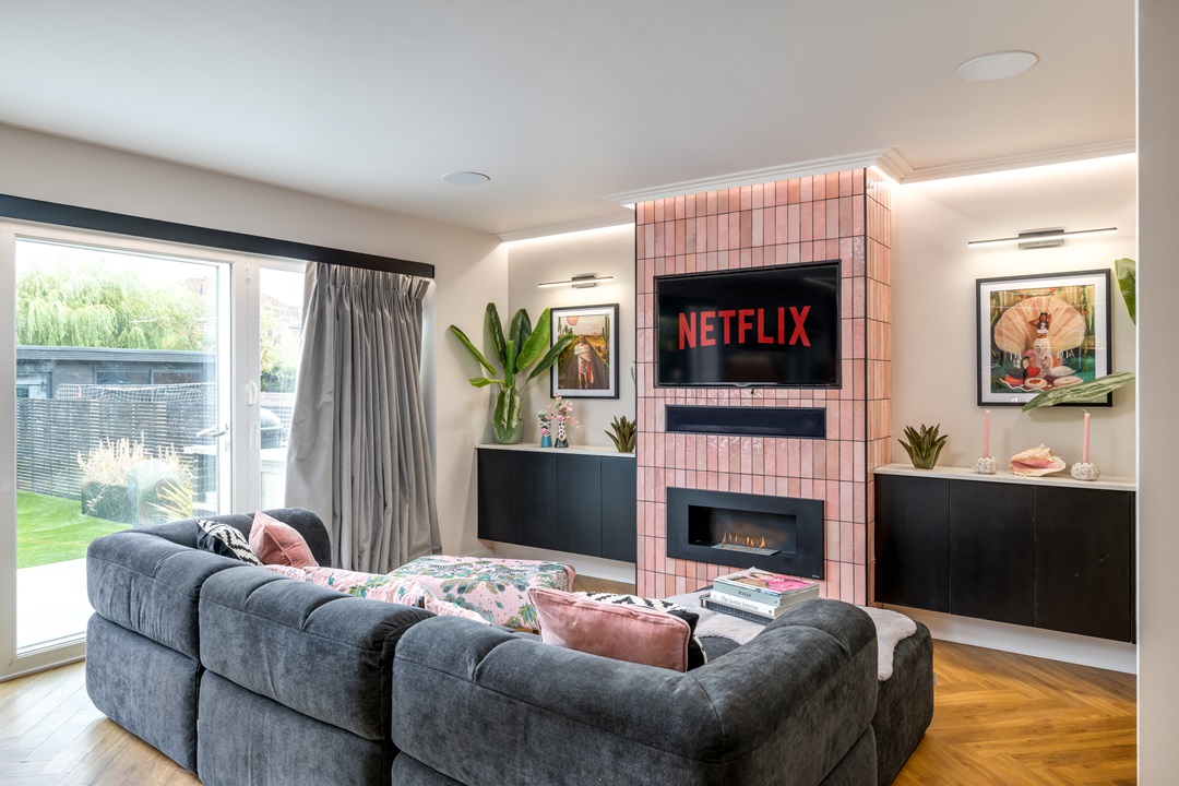 Pink tiled chimney breast with tv and fire place